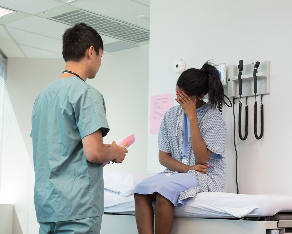 A person in scrubs talking to a patient