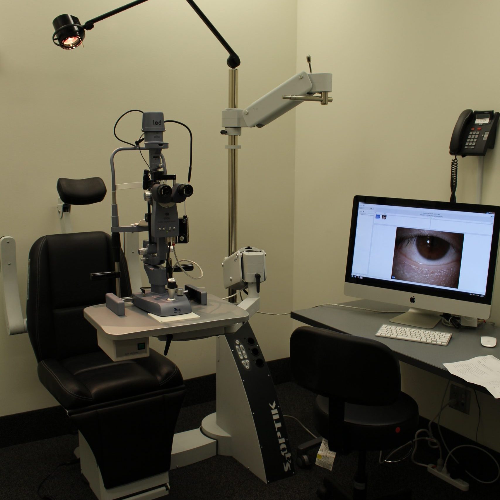 A room fitted with optometry equipment and a screen with an image of an eye being displayed