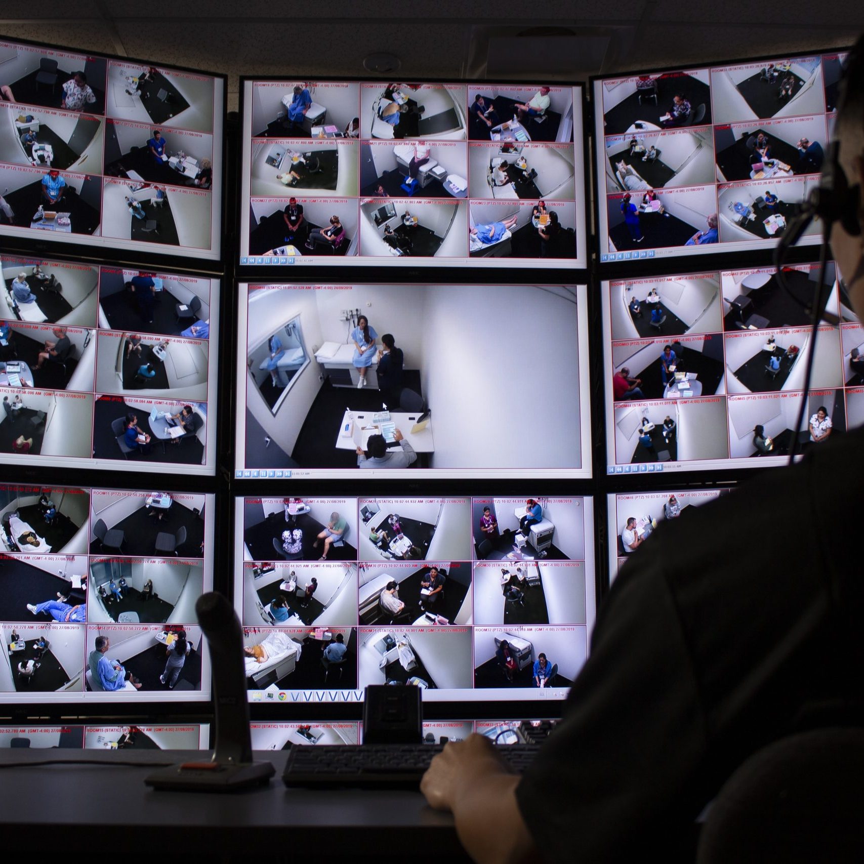 A person watching multiple screens in a control room