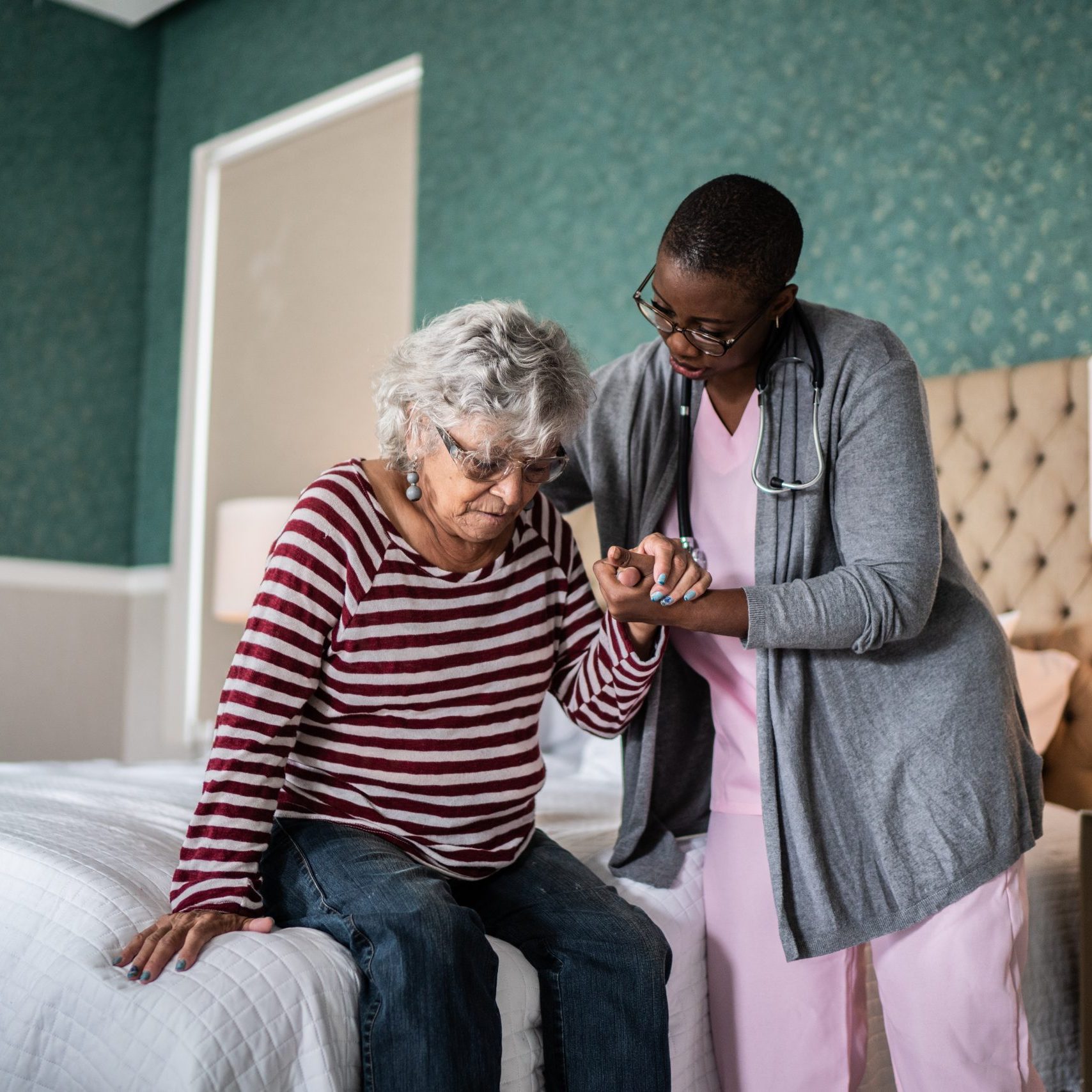 Nurse helping a senior woman standing in the bedroom