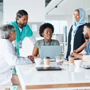 Teamwork, planning and consulting with doctors and laptop for medical, review and healthcare. Medicine, technology and internet with group of people for collaboration, diversity and support in clinic